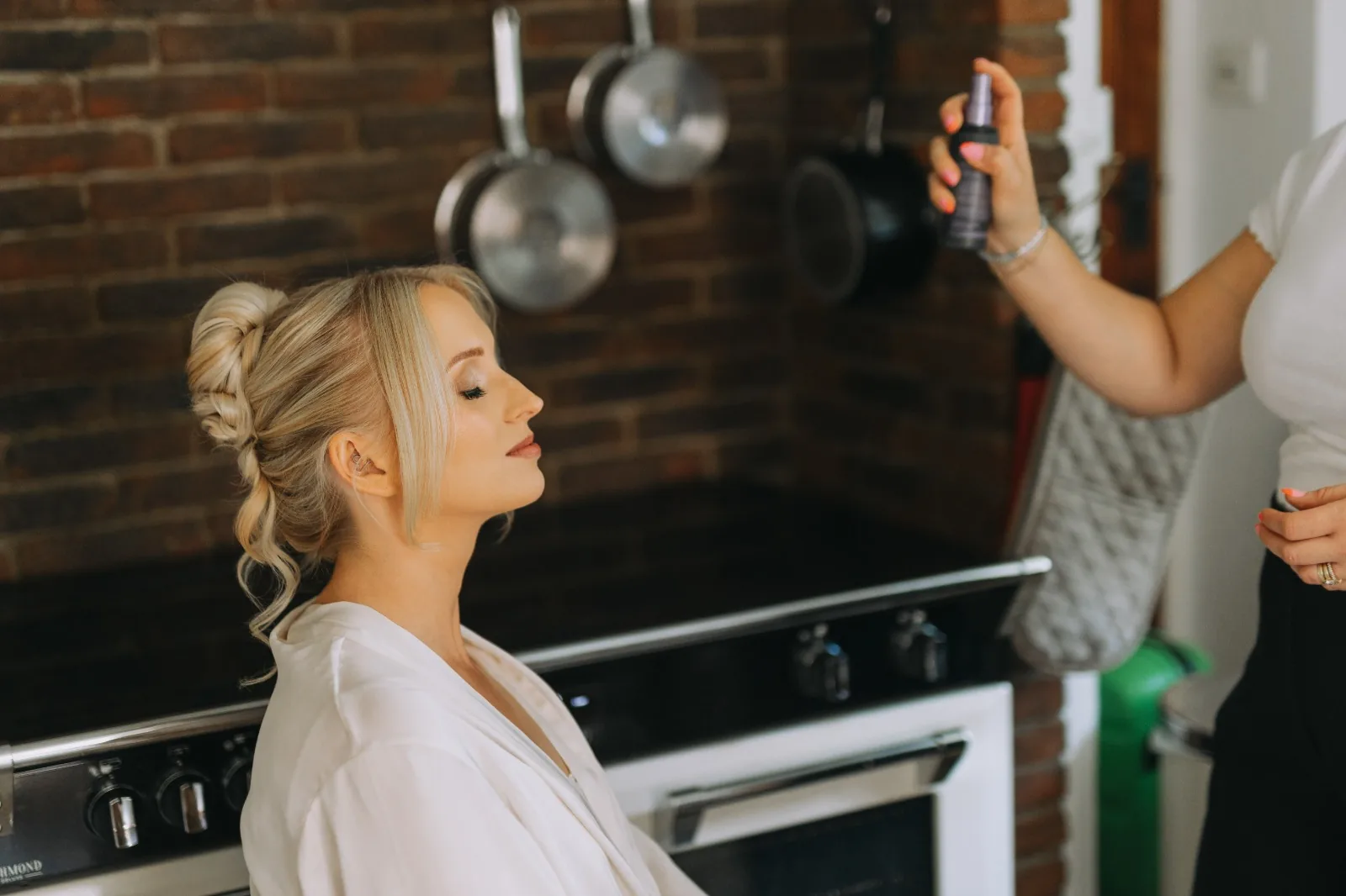 Setting spray being applied over a bride's finished makeup