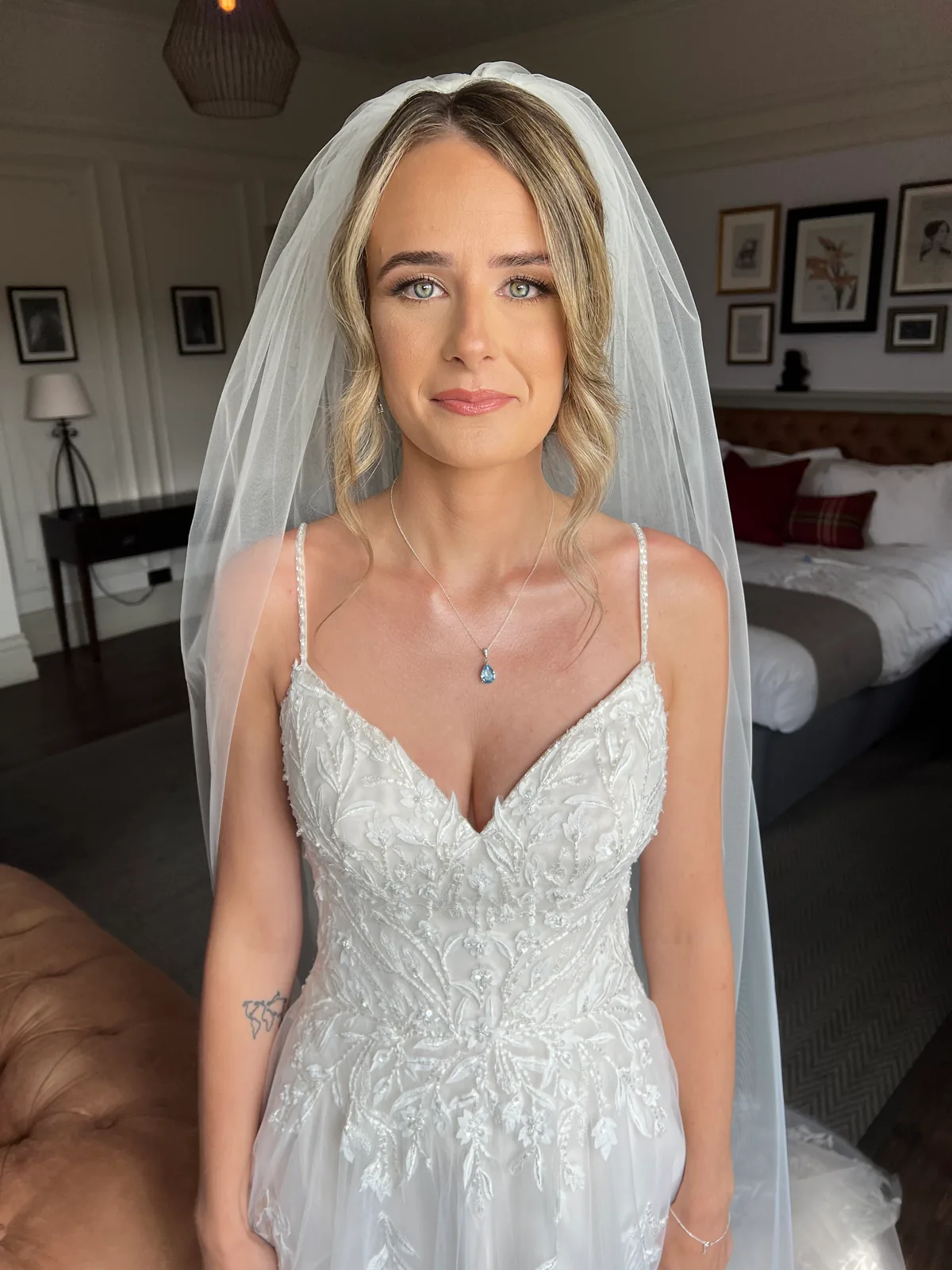 A bride under her veil facing the camera, with softly defined eyes