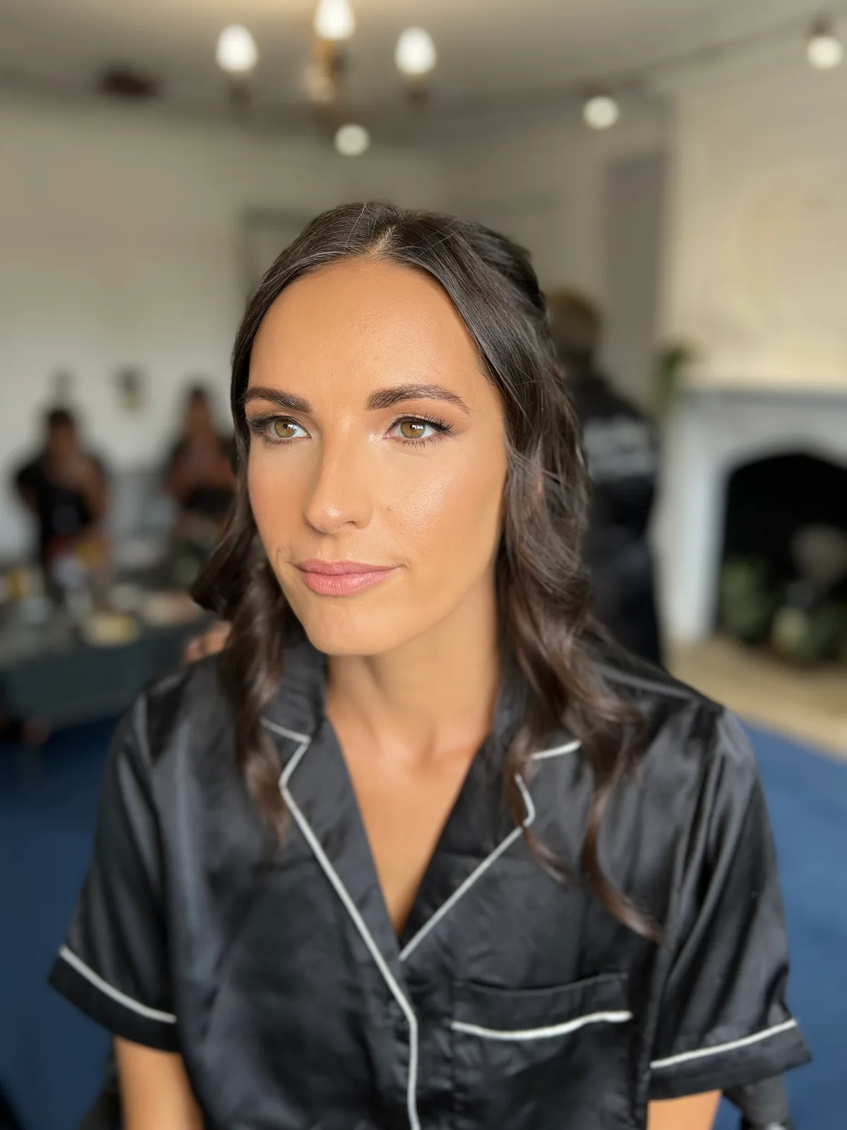 A member of the bridal party in a satin top with soft, defined makeup