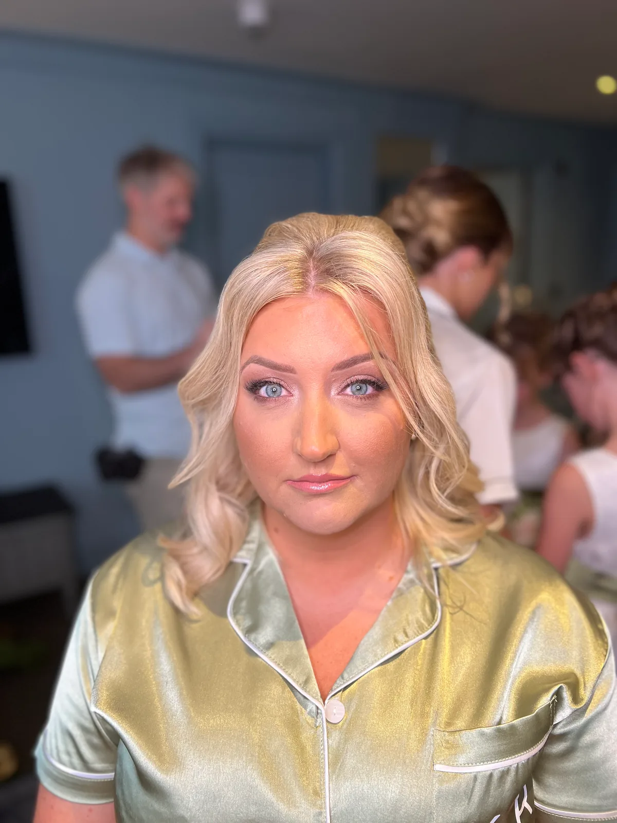 A member of the bridal party in gold satin with warm, defined makeup