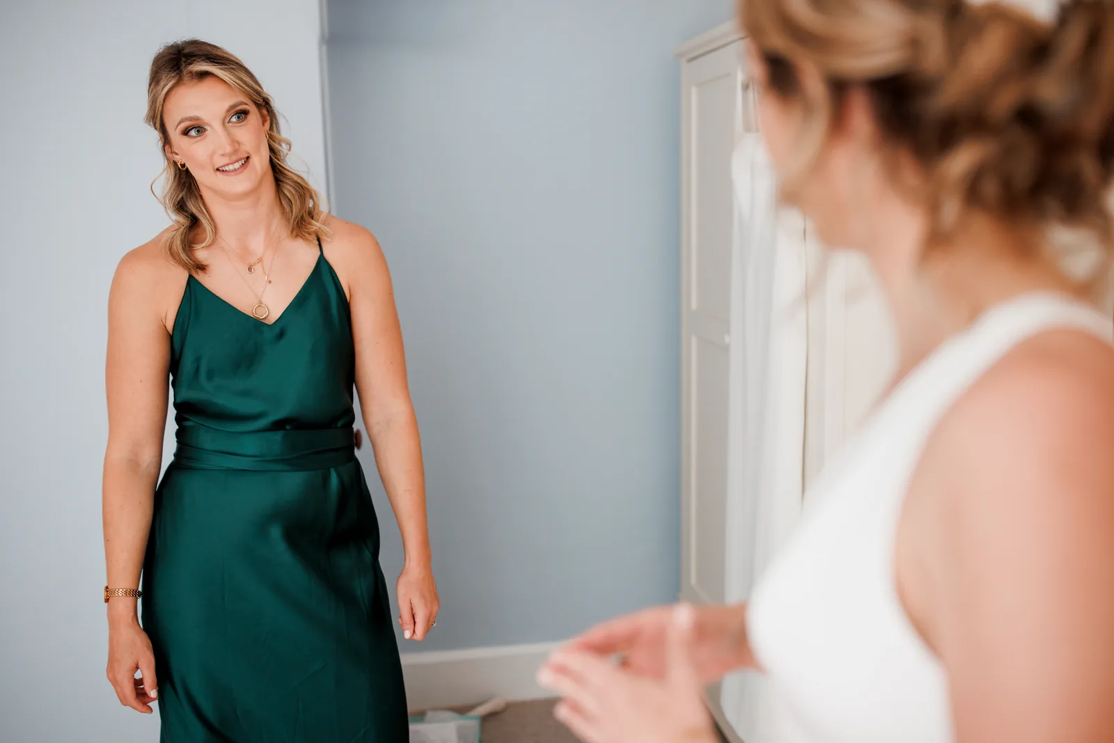 A member of the bridal party in green satin, getting ready