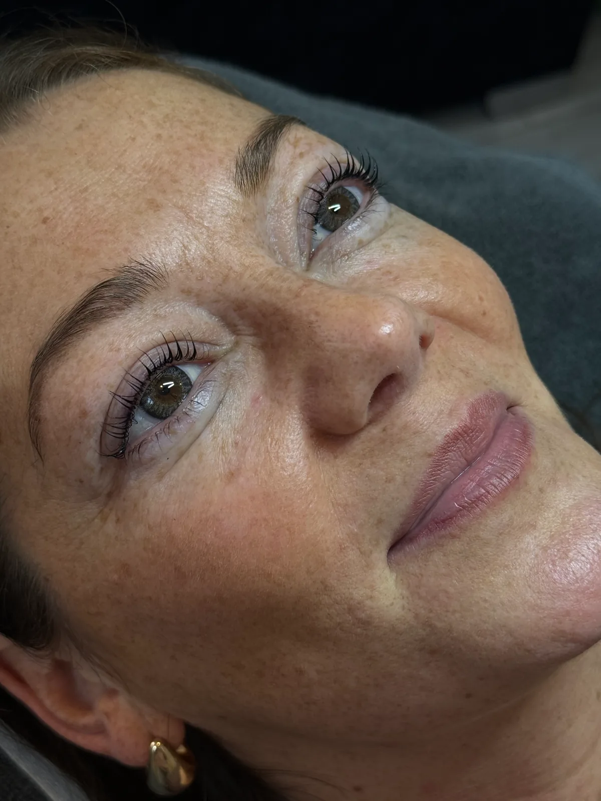 Lifted, tinted lashes and soft brows on a smiling client