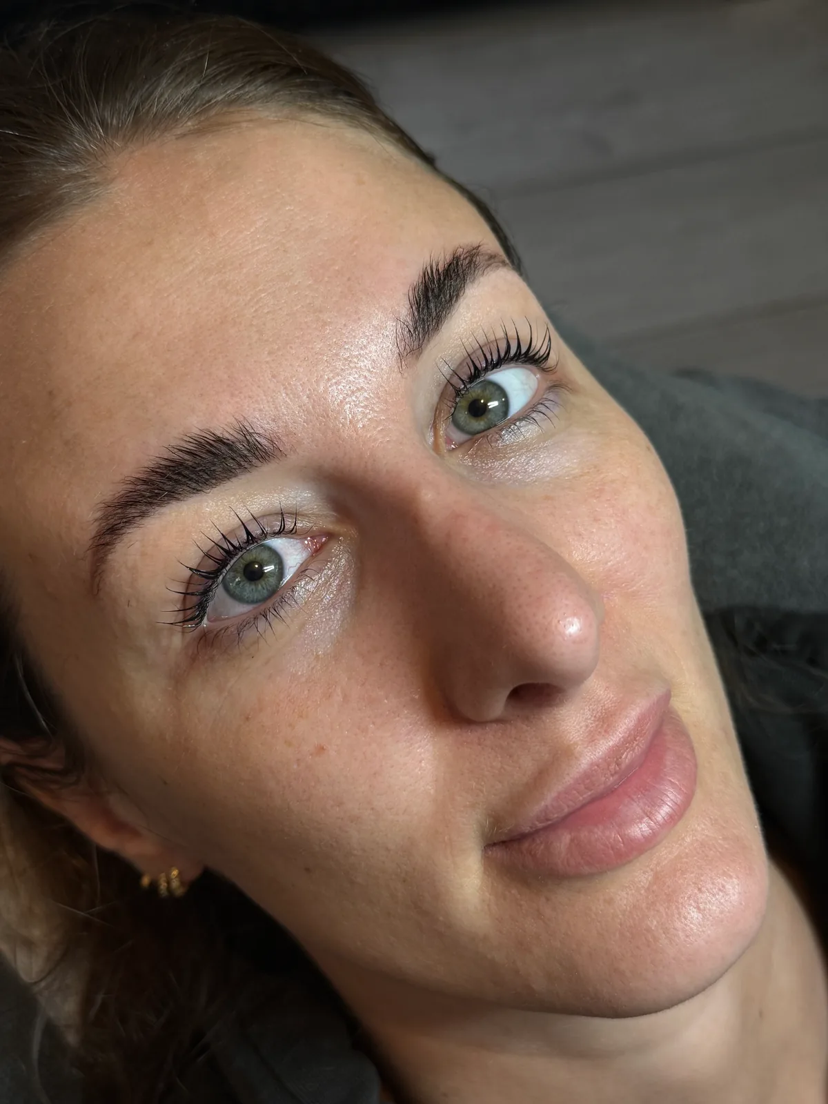 A client looking up to show lifted lashes and shaped brows