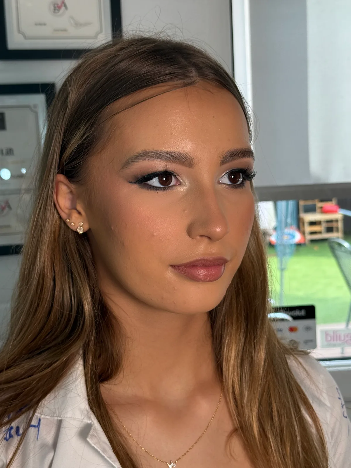 Soft glam occasion makeup with winged liner and a rosy nude lip