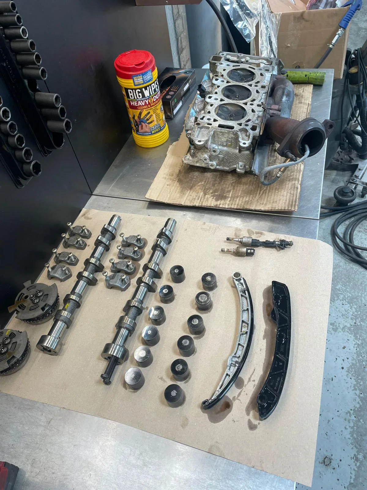 Engine components laid out in order on the bench