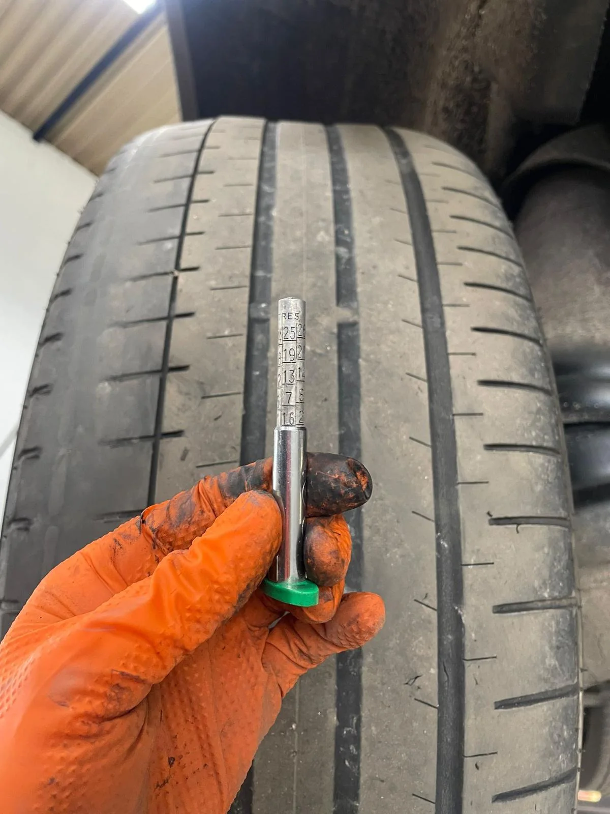 A tyre tread being checked with a gauge